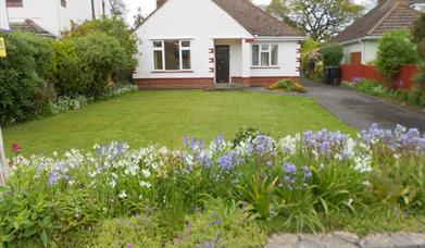 White exterior of modern bungalow with flowers