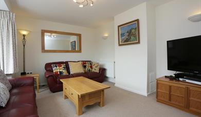 Lounge wit two burgundy sofas and largeTV
