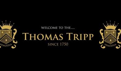 Golden thomas tripp emblems on a black background.