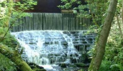 A bridge over cascading river at Chewton Bunny.