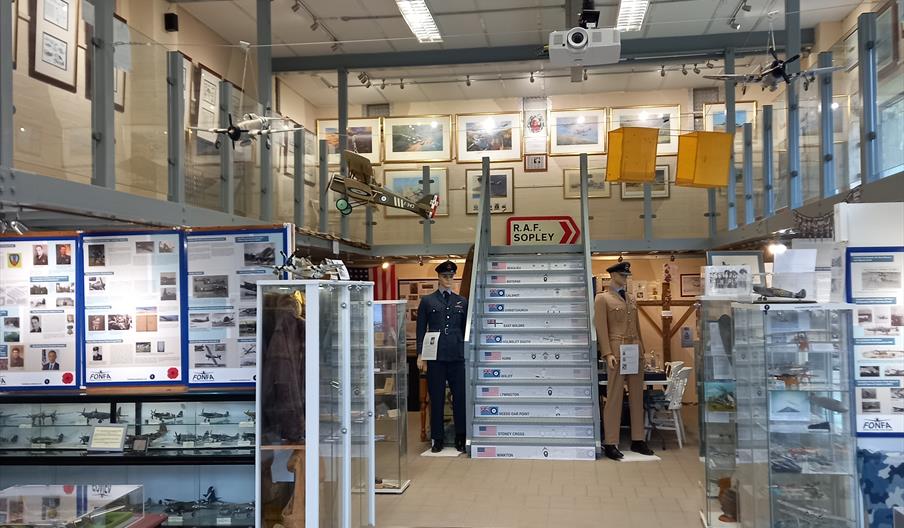 Interior of the aviation museum showing display cases, and pictures on the walls