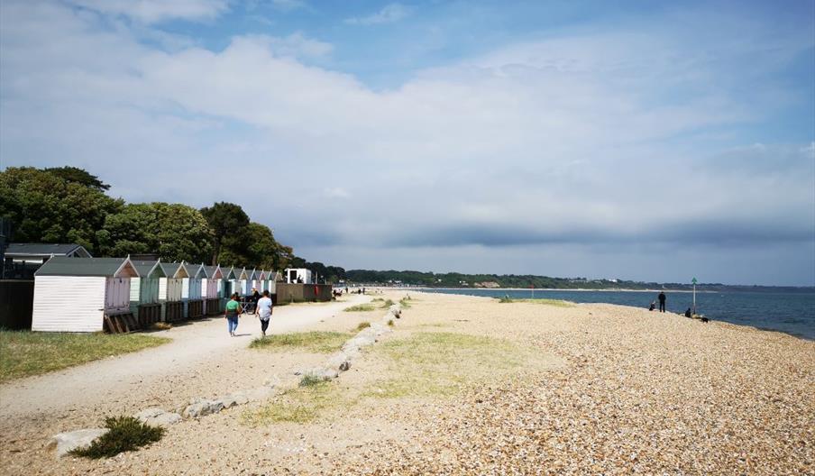 Wide shot of people walking on the dusty promenade at Avon Beach.