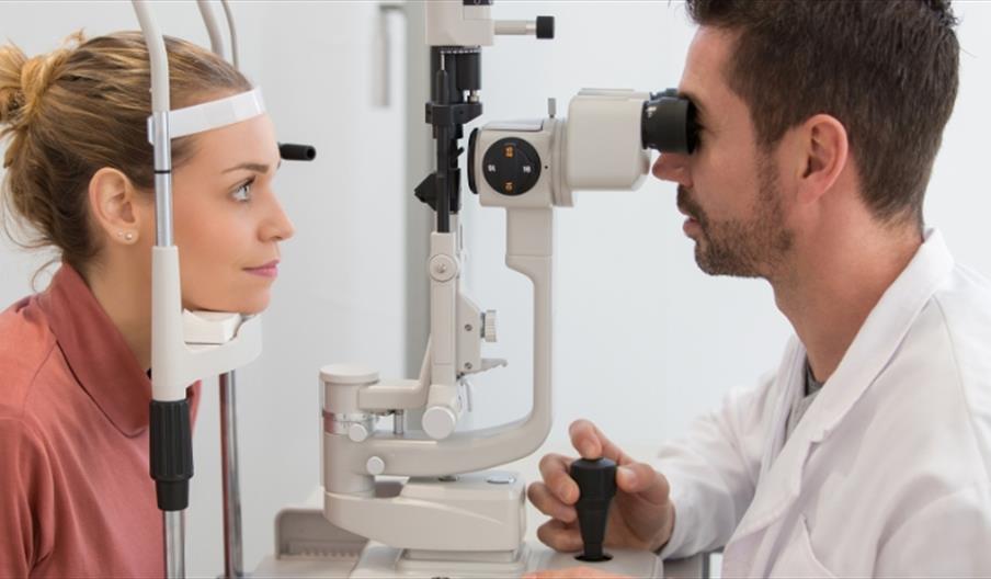 Optician running eye test on patient