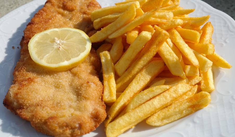 Fish, chips and a slice of lemon on a plate