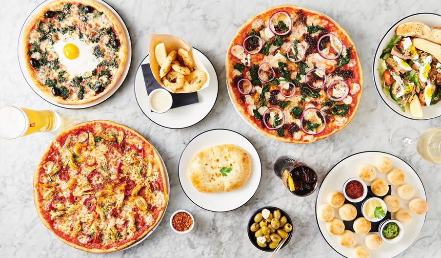 table of pizza and drinks laid out.