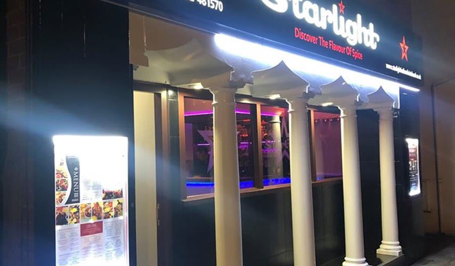 outside of the restaurant lit up at night.