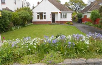 White exterior of modern bungalow with flowers