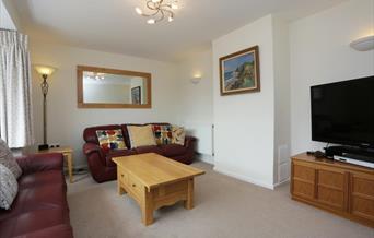 Lounge wit two burgundy sofas and largeTV