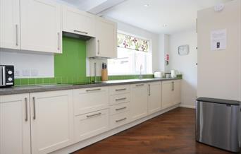Large white kitchen with a hint of green