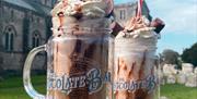 The famous ducking stool milkshakes held in front of the Christchurch priory