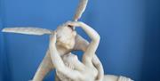 Marble statue of and angel and woman embracing