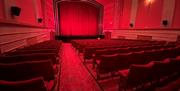 Inside the screen room with red deco red carpet and red seating