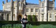 Little boy running on grass in front of castle