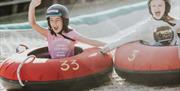 Two girls going down the dry ski slope together on their ringos