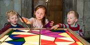 Children playing with interactive stained glass activity