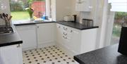 White, clean kitchen with lots of light coming through the windows