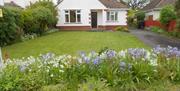 White exterior of modern bungalow with flowers