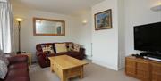 Lounge wit two burgundy sofas and largeTV