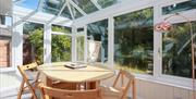 Bright conservatory with dining table and chairs