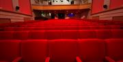 Inside the screen room facing away from the screen with red seating