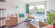 Small suite at Captain’s Club Hotel overlooking the river, with a sofa and chair in the seating area