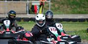 Three people racing in the go karts