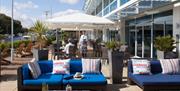 Outdoor terrace with seating and parasols on the water side.